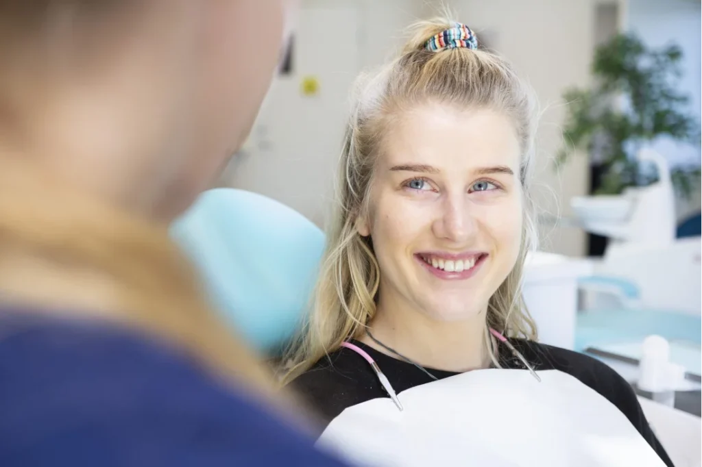 En kvinna sitter i tandläkarstolen hos sin ortodontist